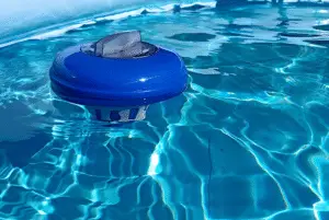 Close-Up Of A Blue And White Floating Chlorine Dispenser Bobbing In Bright, Rippling Swimming Pool Filtration Failure Water For Sanitization