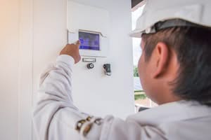 Close-Up View Of A Clean Energy Technician Wearing A White Hard Hat And Work Jacket, Pointing At And Interacting With A Touchscreen Human Machine Interface (Hmi) Panel For A Solar Power Inverter System At A Solar Farm Facility And Check The Smart Pool Automation Repair.