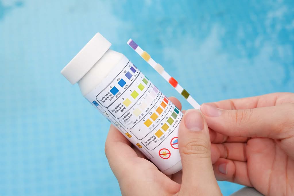 Last-Minute Pool Inspections: Proven Central FL May 2026 Guide 2 Close-Up Of A Technician'S Hands Comparing A Pool Water Test Strip To A Color Chart To Check Ph And Chlorine Balance In Orlando, Florida.