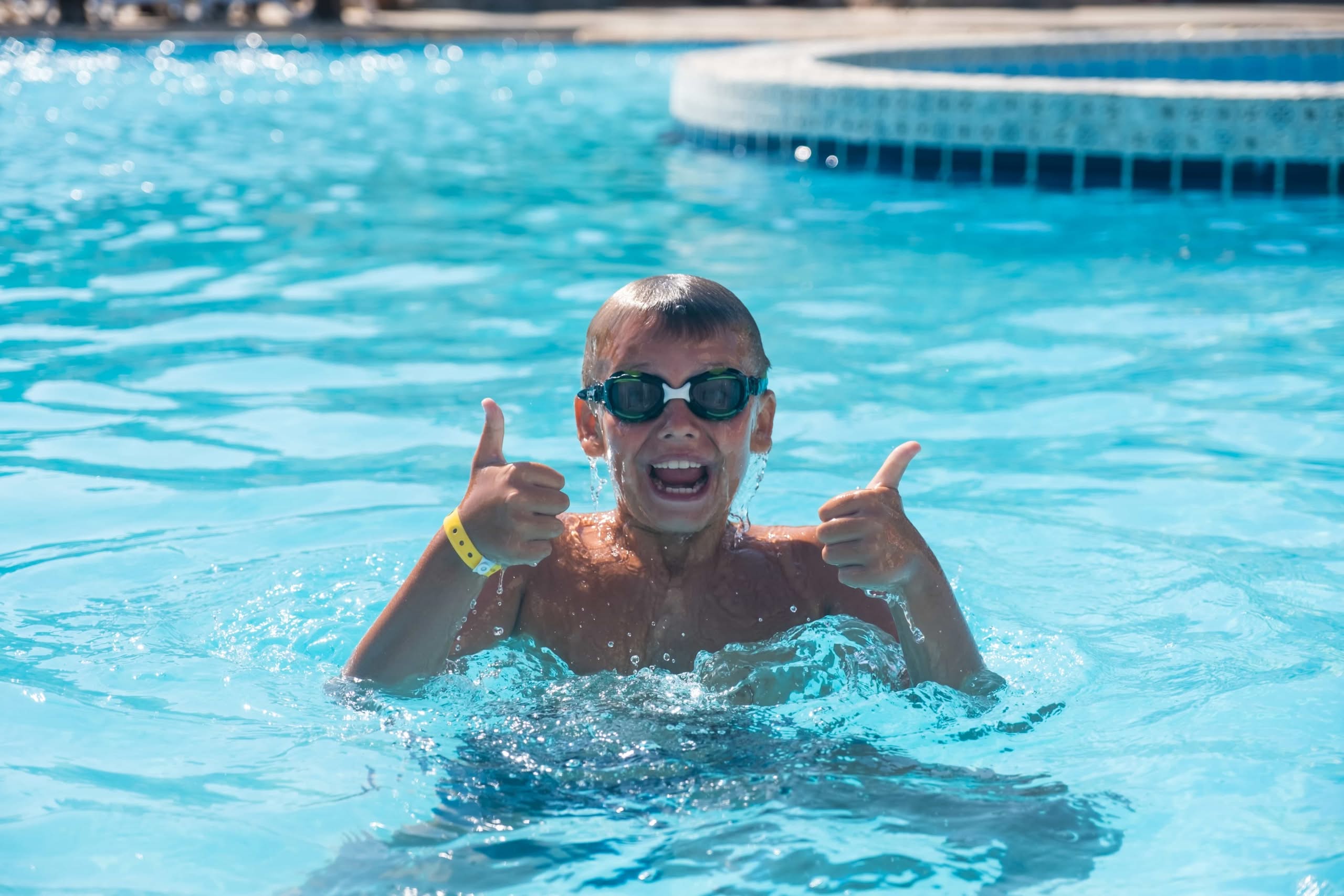A Happy Boy Wearing Swimming Goggles Gives A Thumbs Up While Playing In A Pool During Swimming Lessons In Public Swimming Pools In Ocala At Phoenix, Az.